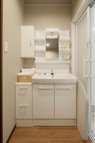 a kitchen with white cabinets and a sink at Guest House Goettingen in Kyoto