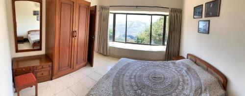 a bedroom with a bed and a large window at Camellia Heights 1&2 in Coonoor