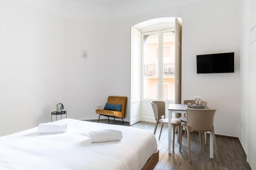 una camera con letto, tavolo e sedie di PugliaMare Room and Apartment by Wonderful Italy a Bisceglie