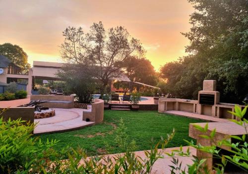 a backyard with a park with a sunset in the background at Imbabali Retreat & Venue in Magaliesburg