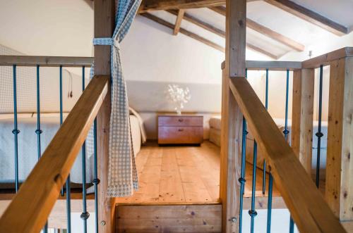a wooden staircase leading to a room with a bed at Rifugium in Greve in Chianti