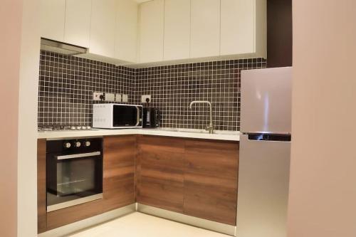a kitchen with a refrigerator and a microwave at Astoria Apartments Lovely One Bedroom Apartment With AC & UPS in Lavington in Nairobi