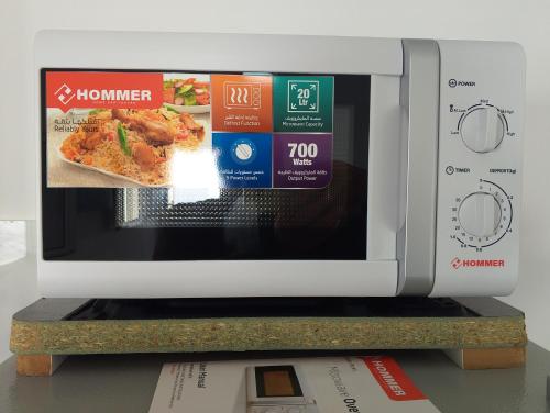 a microwave on a shelf with a pizza inside at Le petit Mimosa - City Center in Tataouine