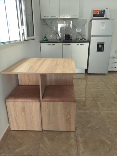 a kitchen with a wooden table and a counter top at Le petit Mimosa - City Center in Tataouine