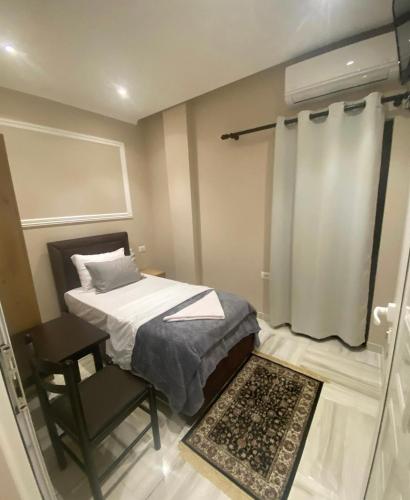 una piccola camera con letto e sedia di HOTEL EMANUEL a Vorë
