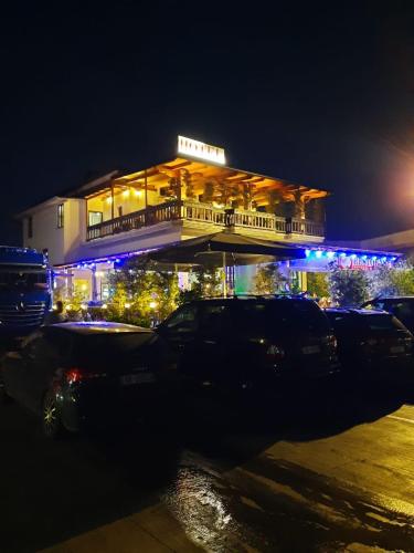 un edificio con auto parcheggiate di fronte ad esso di notte di HOTEL EMANUEL a Vorë