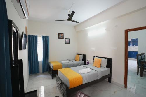 a bedroom with two beds and a window at Yellow Bells Serviced Apartments Hitech City in Kondapur