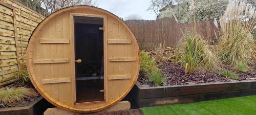 - un sauna en bois avec une porte en bois dans le jardin dans l'établissement Maison Familiale proche Disney, à Condé-Sainte-Libiaire