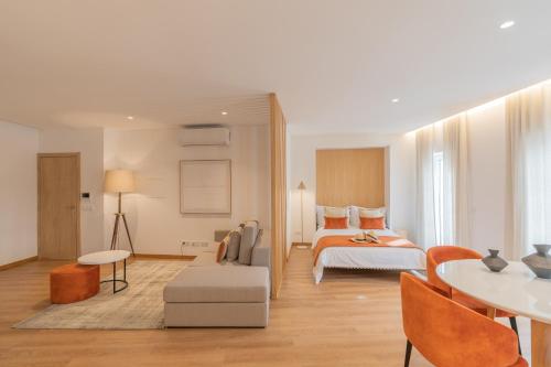 Habitación de hotel con cama, mesa y sillas en Ana's Apartments en Sines
