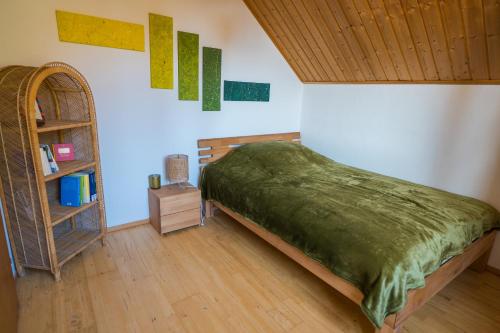 Naturoase Säntisbligg am Bach und Wald في Kradolf: غرفة نوم مع سرير ورف كتاب