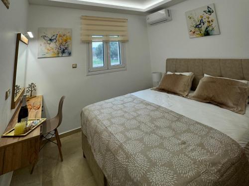 una camera con letto, tavolo e finestra di Paul’s Garden Luxury House a Haraki