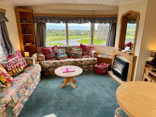 uma sala de estar com um sofá e uma mesa em Snowdon Bay - North Wales - Stunning Llyn Peninsula Mountain & Ocean Views em Pwllheli