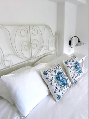 a white bed with blue and white pillows on it at Suite Villa Carolina in Capri