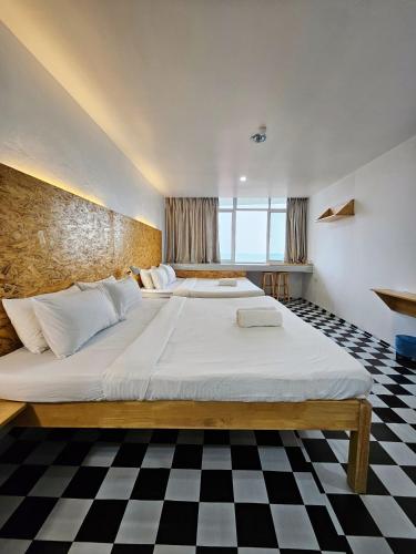 two beds in a bedroom with a checkered floor at The 60 in George Town