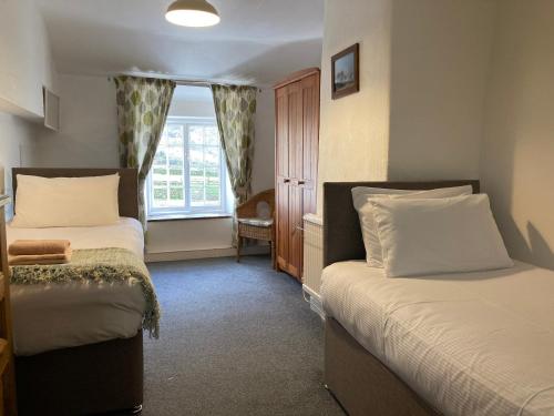 a bedroom with two beds and a window at Burnthwaite Farm B&B 