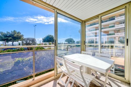 a balcony with a white table and two chairs at Magnifique 2 pièces vue mer - Parking Proche plage in Saint-Laurent-du-Var