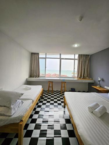 two beds in a room with a checkered floor at The 60 in George Town