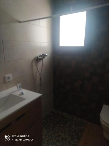 baño con aseo y lavabo y ventana en Bramer 6 Canyelles en Rosas