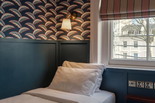ロンドンにあるセント デイビス ホテル パディントンの窓付きの部屋で、ベッド1台(枕付)