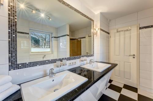 een badkamer met 2 wastafels en een spiegel bij Haus Waldoase Ahlbeck in Ahlbeck