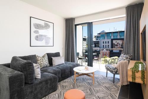 a living room with a couch and a table at Xenia Aparthotel by Totalstay in Cape Town