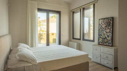 Un dormitorio con una cama y una ventana grande. en ONDA 8, Emma Villas, en Santa Maria di Scacciano