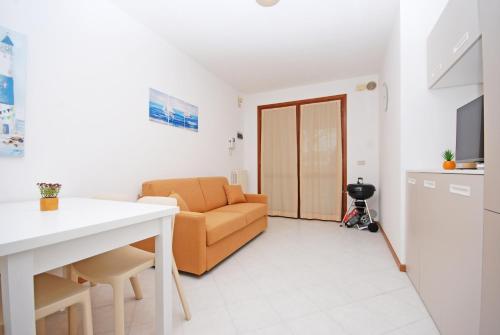 uma sala de estar com um sofá e uma cozinha em Corallo Cavallino em Cavallino-Treporti