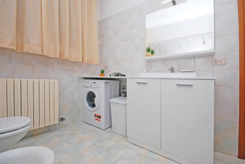 a bathroom with a washing machine and a washer at Corallo Cavallino in Cavallino-Treporti