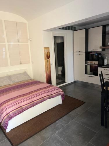 a bedroom with a bed and a kitchen at [FREE PARKING]Appartamento angolo di relax!!! in Rivoli