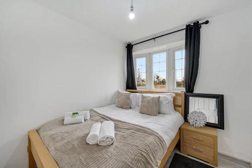 - une chambre avec un lit et des chaussons blancs dans l'établissement Pass the Keys Superb 3 bed Close to Airport, à Wythenshawe