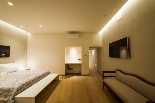 Atto Primo Studio Apartment في فيرونا: غرفة نوم بسرير واريكة ومكتب