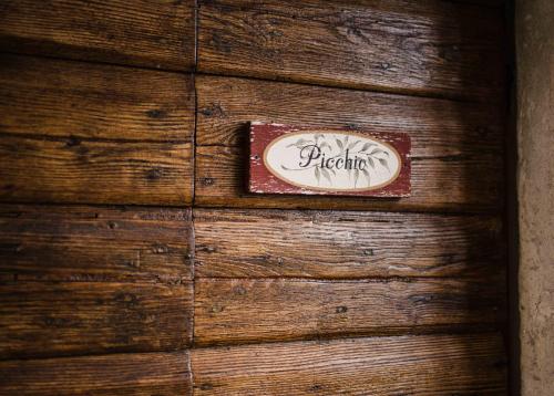 a sign on the side of a wooden wall at Rifugium in Greve in Chianti