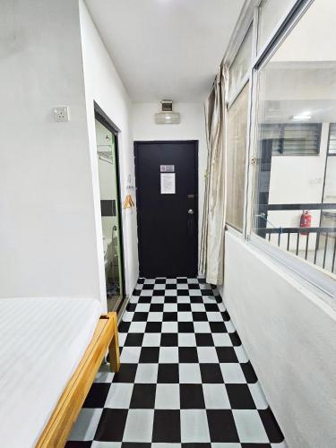 a hallway with a black door and a checkered floor at The 60 in George Town