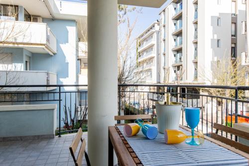 un tavolo con sedie e bicchieri su un balcone di Appartamenti Desi Riccione a Riccione