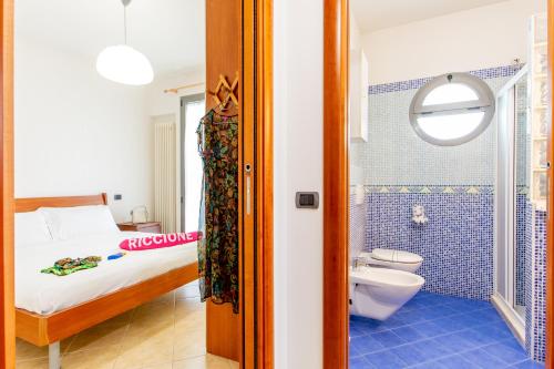 una camera con letto e un bagno con servizi igienici di Appartamenti Desi Riccione a Riccione