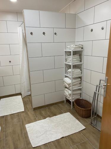 La salle de bains est pourvue de murs en carrelage blanc et de serviettes blanches. dans l'établissement Ferienwohnung Kornkäfer 2, à Mochau