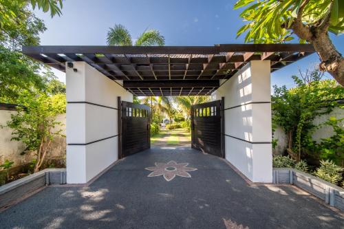 an entrance to a house with two garage doors at BougainVilla - Oceanfront villa with Cook, ideal for Weddings and Events in Keramas