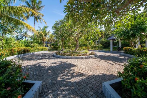 a brick walkway with a tree in the middle at BougainVilla - Oceanfront villa with Cook, ideal for Weddings and Events in Keramas