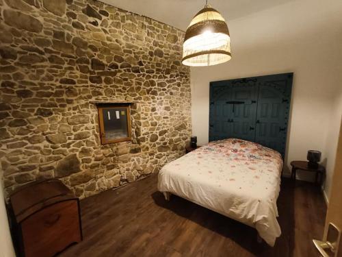 貝格海姆的住宿－Grange rénovée dans cour privée avec jardin，一间卧室设有一张床和石墙