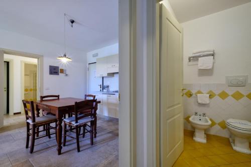 a kitchen and dining room with a table and a toilet at Poggio all'Agnello Sport & Family Holidays in Populonia