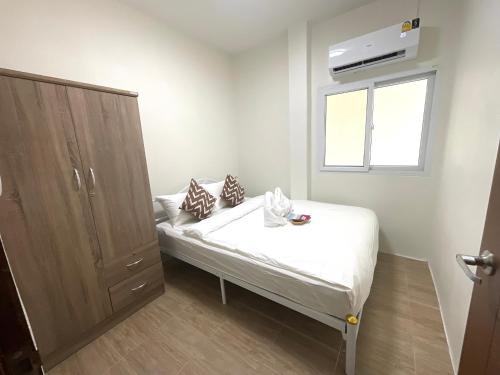 a small bedroom with a bed and a window at Yourbed & House in Bang Rak Beach
