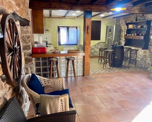 a kitchen and living room with a counter and chairs at Casa en aldea frente a la Sierra de el Sueve in Colunga