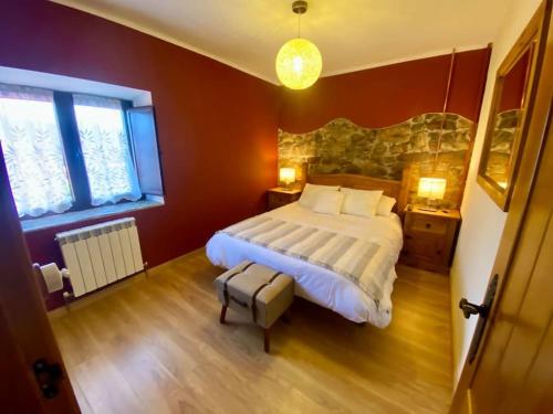 a bedroom with a large bed and two windows at Casa en aldea frente a la Sierra de el Sueve in Colunga