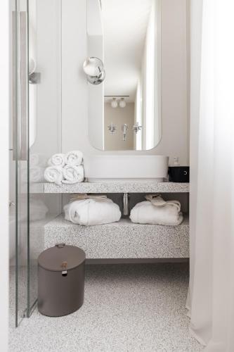 a bathroom with a sink with a mirror and towels at LA CASA DI LAURA in Valdobbiadene