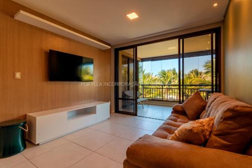 a living room with a couch and a tv at MANDARA LANAI - BL 25, APTO 202 - Aquiraz in Aquiraz