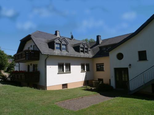ein weißes Haus mit schwarzem Dach in der Unterkunft Apartment with sauna in Eschfeld in Eschfeld