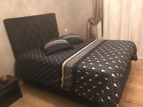 - un lit avec une couette et des oreillers en noir et blanc dans l'établissement Hôte.Superhost, à Aulnay-sous-Bois