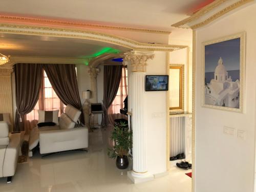 - un salon avec un canapé et un pilier dans l'établissement Hôte.Superhost, à Aulnay-sous-Bois