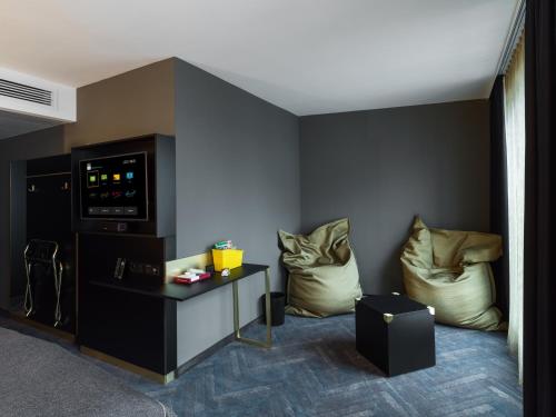 a living room with two chairs and a table at Holiday Inn - the niu, Cobbles Essen by IHG in Essen