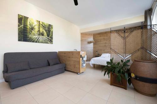 ein Wohnzimmer mit einem Sofa und einem Bett in der Unterkunft Apartamento familiar exterior en la costa de Zarautz - Oasis Palm in Zarautz